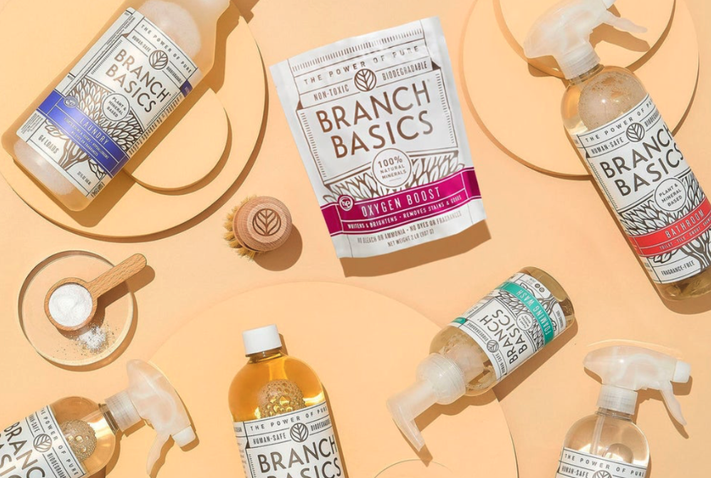 Branch Basic cleaning concentrate and refill bottles sit on a yellow backdrop. 
