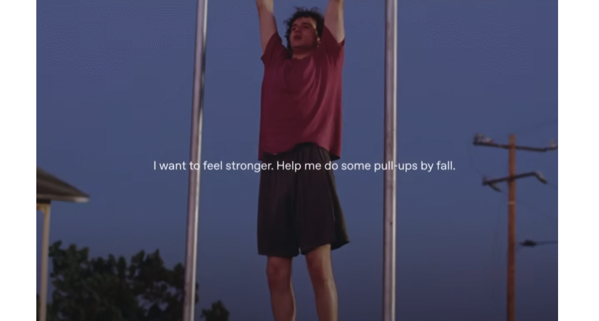 Still shot from ChatGPT's Pull Up ad showing a young man in a red t-shirt doing a pull up