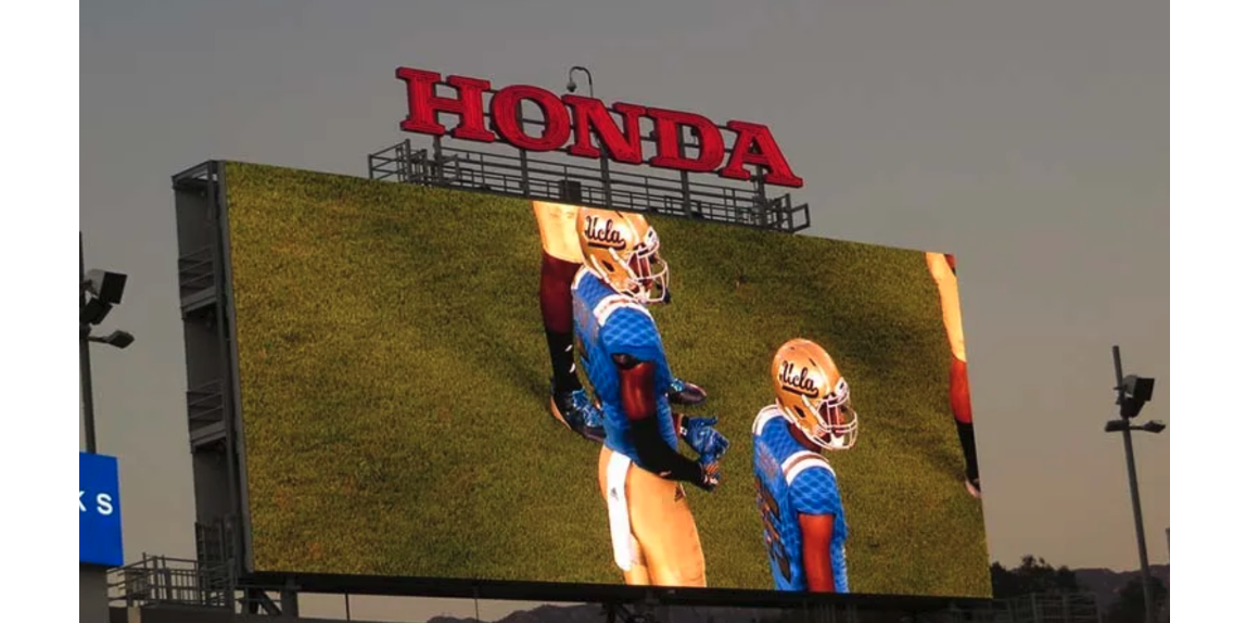 Jumbotron shows football players on the field.