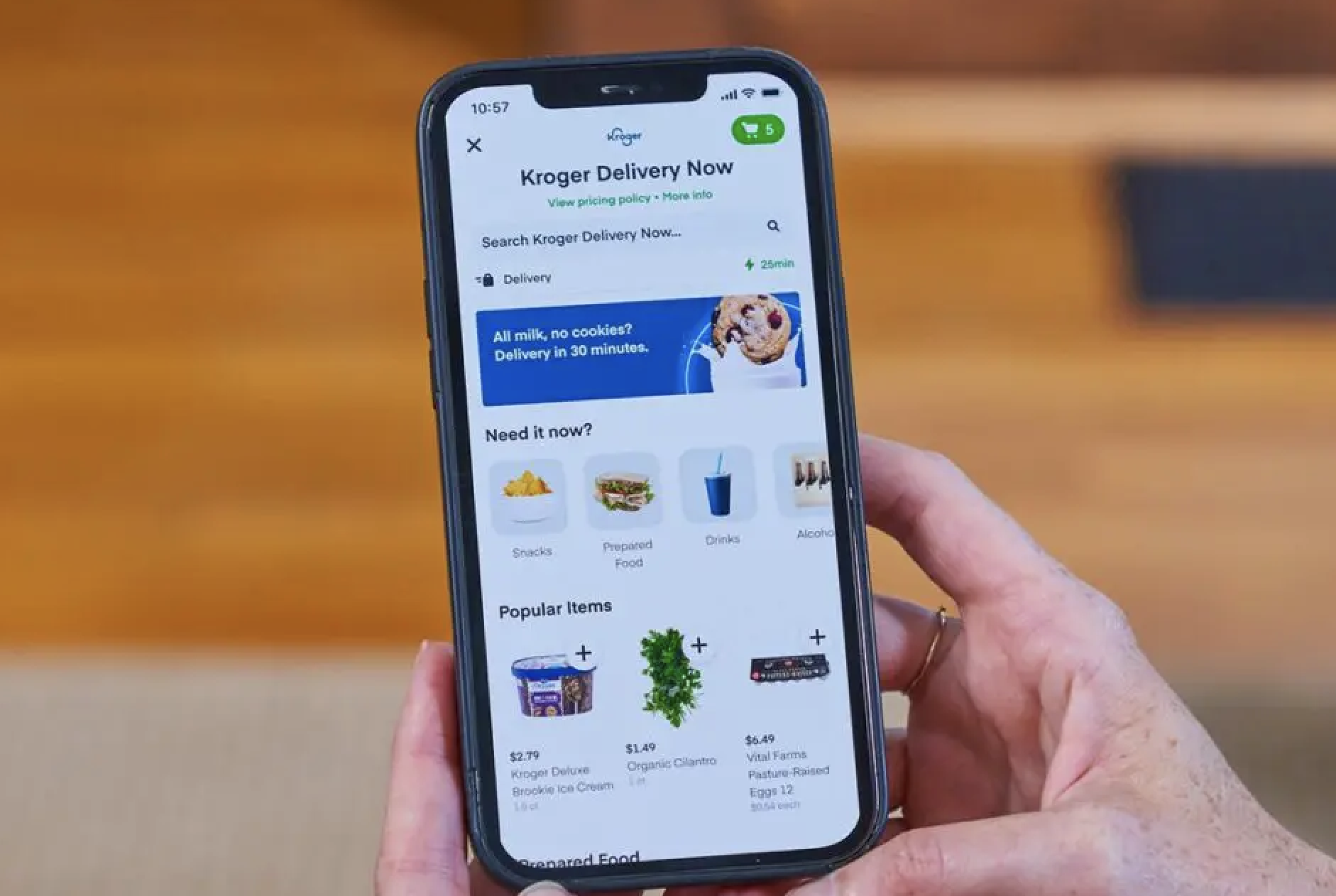 Image of someone holding a cell phone with the Kroger app opened on screen