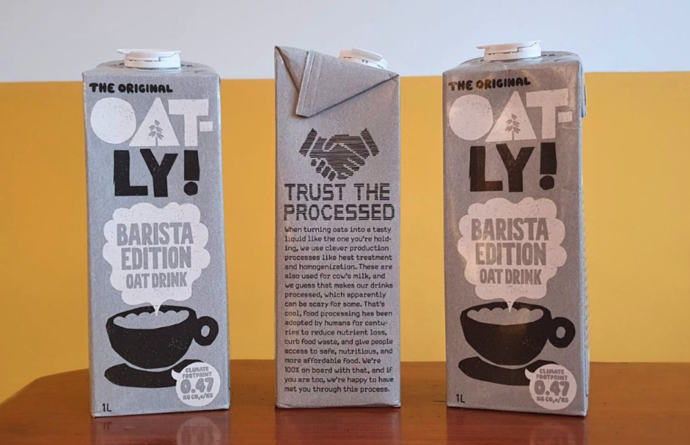 Three Oatly cartons sit on a table. 