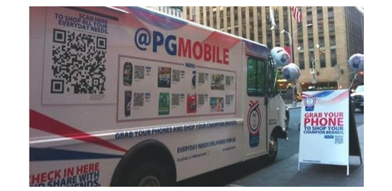 A photo of a box truck with a QR code on the side and the words “@PGMOBILE” and “Grab your phone” 
