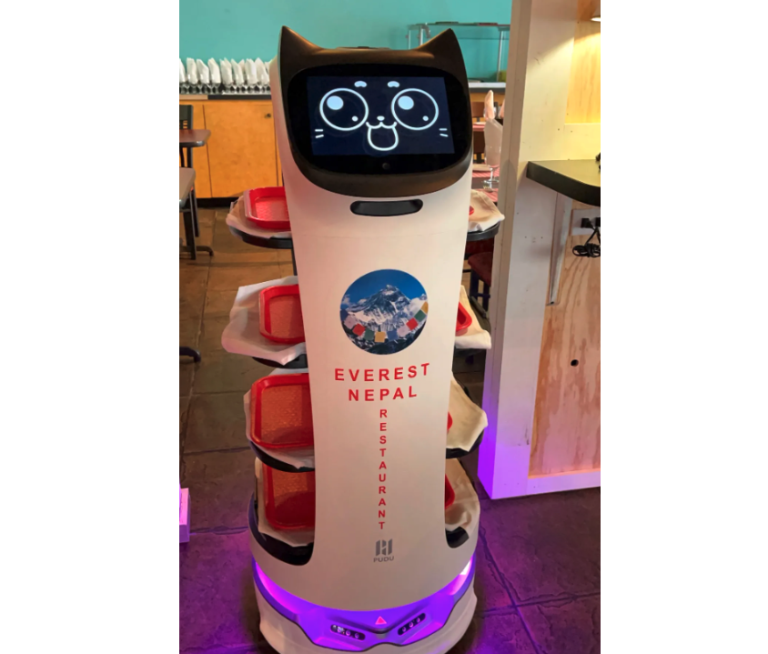 Robot waiter with cat ears and digital cat face moves around a restaurant with red trays stacked on it. 