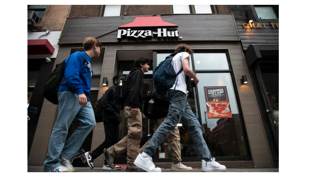 teens walk past Pizza Hut