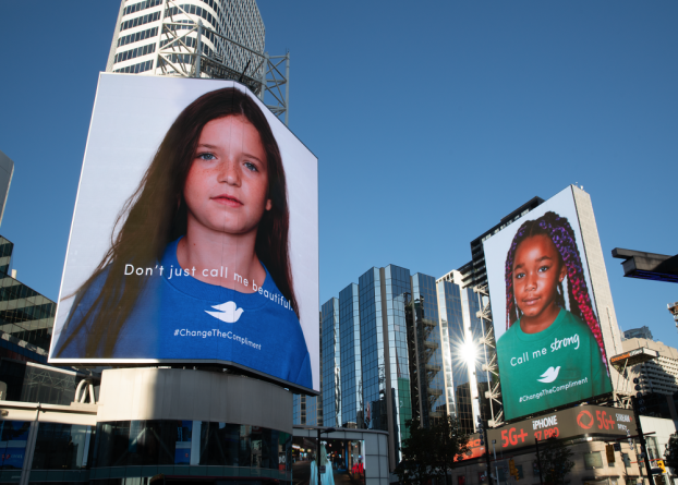 Dove's Change the Compliment campaign billboards showing headshots of two young girls on tall city building and the words 