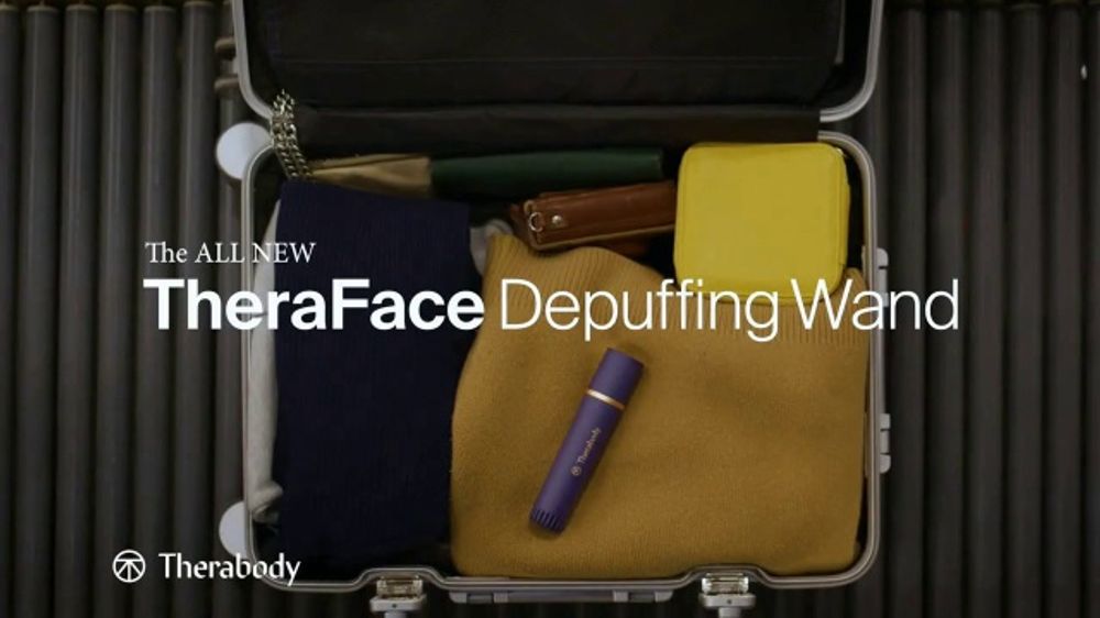 Shot of the Therabody Depuffing Wand atop luggage 